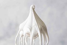 a close up of a whisk with white icing on it's head