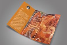 an orange and white brochure is open to show the art work on display