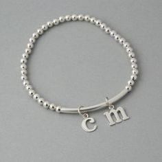 This is my new go to bracelet. Made for easy wear with high quality stretchy cord. Sterling silver beaded bracelet with a sterling bar. Silver initials dangle perfectly. Wear it alone or layered up! So cute. Listing is for one bracelet. **Please leave initial choices in notes at checkout** Comes in a Organza bag, gift box available or additional $2 PLEASE NOTE WHEN ORDERING, MEASURE YOUR WRIST, THEN ADD 1/2 INCH FOR A COMFORTABLE FIT. bracelet is adjustable by 1/2 inch. x-small 5-6 inches small Silver Minimalist Stretch Bracelet As Gift, Silver Stackable Name Bracelet For Everyday, Everyday Silver Stackable Name Bracelet, Adjustable Sterling Silver Charm Bracelet With Initials, Adjustable Silver Jewelry With Letter Beads, Adjustable Hypoallergenic Sterling Silver Stretch Bracelet, Classic Adjustable Sterling Silver Stretch Bracelet, Silver Charm Bracelet With Letter Beads For Gift, Silver Charm Bracelet With Letter Beads As Gift