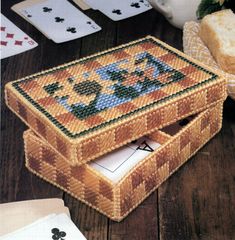 a wooden table topped with playing cards and a basket