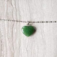 Beautiful heart jade necklace, Gorgeous translucent green. The pendant is made from nephrite jade mined from British Columbia, Canada. We currently only have the gold plated jump ring in stock. The pendant comes with a stainless steel jumpring. Option to buy sterling silver chain necklaces. Jade brings harmony and contentment to the wearer. In Asian cultures, Jade is revered as the good luck stone which can bring happiness, wealth, and friendship. 15mm x 15mm x 4.85mm 4.6 grams Heart Charm Necklace For May Birthstone Gift, May Birthstone Heart Pendant Necklace, Heart Shaped May Birthstone Necklace With Heart Charm, Green Heart Cut Necklace For Gift, Dainty Green Heart Jewelry, Green Dainty Jewelry For Valentine's Day, Green Heart Pendant Necklace For Gift, Green Heart Pendant Necklace As Gift, Green Heart Pendant Necklace Gift