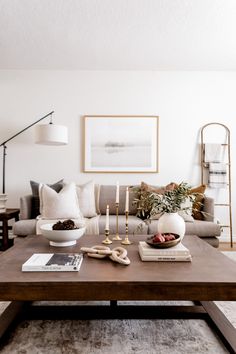 a living room with a couch, coffee table and pictures on the wall above it