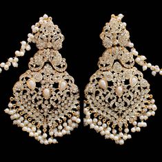 This majestic set has striking, intricate motifs and complex stone work, making it a stunning piece of handiwork! Gloriously enhanced with stone work, this set is one of the most extraordinary pieces in our collection. The set includes a necklace, a matching maang teekah, a jhoomar/passa and a pair of beautiful earrings. Approximate earrings length is 3.75". Gold-plated on high-quality brass as base metal. Made by order. Kindly allow 5-7 weeks for the delivery of this item. For custom or urgent Festive Stone Work Chandelier Earrings For Reception, Designer Stone Work Jhumkas For Festive Occasions, Temple Jewelry Style Chandelier Earrings For Reception, Elegant Kundan Bridal Earrings With Stone Work, Bollywood Style Chandbali Earrings For Designer Wear, Elegant Designer Festive Jhumkas, Designer Chandbalis With Tilla For Diwali, Festive Elegant Designer Jhumkas, Designer Tilla Chandbalis For Diwali