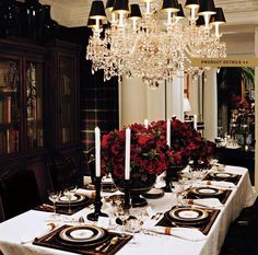 a dining room table is set with place settings and flowers on the centerpieces