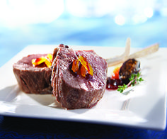 a piece of meat sitting on top of a white plate next to a blue table