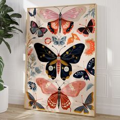 a painting with many butterflies on it next to a potted plant and white wall