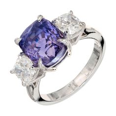 Natural color change 7.06ct cushion cut Sapphire and diamond engagement ring. GIA certified to change color from violet to purple in different light. Accented with 2 antique cushion cut diamonds in a platinum three-stone setting. 1 antique cushion cut color change violet to purple Sapphire, approx. total weight 7.06cts, VS, 8.48 x 9.80 x 8.60mm, GIA certificate #2155677349 2 antique cushion cut diamonds, approx. total weight 1.46cts, G, VS1 to VS2, 5.5 to 5.6mm Size 6.5 and sizable Width at top: Lavender Sapphire, Antique Cushion Cut Diamond, Platinum Engagement Rings Vintage, Sapphire And Diamond Engagement Ring, Antique Cushion, Gia Certificate, Contemporary Engagement Rings, Amethyst Ring Engagement, Modern Engagement Rings