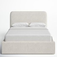 a bed with white linens and pillows on it's headboard is shown