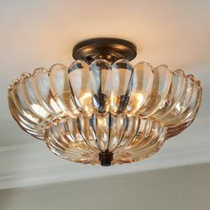 a chandelier hanging from the ceiling with clear glass petals on it's sides