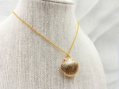 "A gorgeous and beautiful gold seashell locket necklace. It features a shining gold seashell and suspends in a gold finished brass chain along with lobster claw clasp closure. The shell locket inside can hold pictures in both side 16mm x 14mm. The necklace is available in seashell locket necklace only, or adding a stimulated cream white pearl charm along with the seashell locket necklace. The pearl is genuine Swarovski 6mm pearl. It is a wonderful idea for gift giving or as a little treat for yo Shell Shape Charm Necklace As A Gift, Shell Charm Necklace As A Gift, Shell Pendant Charm Necklaces For Gifts, Shell Charm Necklaces As Gift, Gold Shell Necklace Perfect As A Gift, Gold Shell Necklace For Gift, Gold Shell Jewelry As A Gift, Gold Shell Necklace Gift, Gold Shell Necklace As A Gift