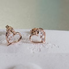 "Sweetly and symbolic are these heart-shaped stud earrings. Available in 14K yellow rose or white gold, each open heart-shaped earring is half-lined with shimmering diamonds, while the other half is smoothly polished. ♥ Absolutely the perfect gift for any occasion and stacks well with other Earring styles. Detail: Height: 9.4mm Width:9.5mm Thickness: 1.3mm Stone Material: Available in Mined Diamond or Cubic Zirconia Stone Shape: Round Total Number of Stones: 10 Stone Setting: Prong Metal: Solid Pierced Earrings As A Valentine's Day Gift For Her, Elegant Heart Cut Earrings For Gift, Elegant Rose Gold Heart Cut Earrings, Fine Jewelry Heart Pendant Earrings For Valentine's Day, Rose Gold Heart Pendant Earrings For Anniversary, Heart Pendant Earrings For Valentine's Day, Heart Charm Round Earrings For Valentine's Day, Valentine's Day Fine Jewelry Heart Pendant Earrings, Valentine's Day Heart Pendant Fine Earrings