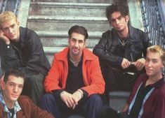 a group of young men sitting next to each other on top of stairs in front of steps