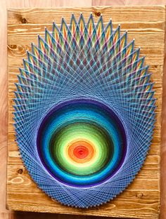 a colorful art piece is displayed on a wooden surface