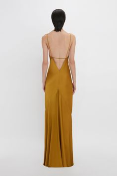 Referencing Victoria’s favourite style decade – the 1990s – this camisole-slip dress in rich Harvest Gold is cut from fluid crepe back satin for an effortless silhouette. With a scoop neckline to the front and deep-V at the back with delicate spaghetti strap detailing, it has a provocative but playful appeal. The floor-pooling skirt is given additional volume with a godet insert at the back. Styled with the Perfume Bottle Necklace Victoria Beckham Low Back Cami Floor-Length Dress In Harvest Gold Size 12 Uk, Harvest Gold, People Clothes, Italy Outfits, Wedding People, Satin Cami, Bottle Necklace, The 1990s, Floor Length Dresses