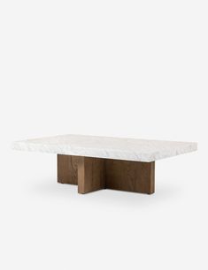 a white marble table with wooden legs and a square top, on a grey background