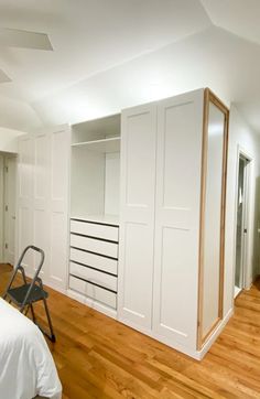 an empty bedroom with white closets and hard wood flooring in the middle of it