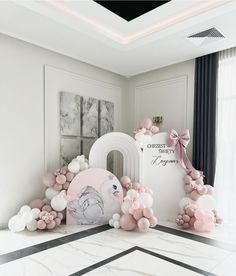 a pink and white room with balloons on the floor