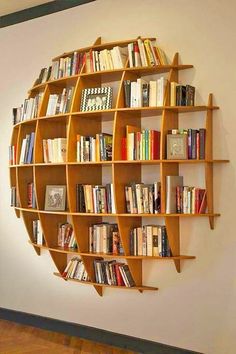 a bookshelf filled with lots of books on top of a wall next to a window