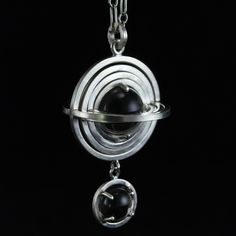 Hand fabricated from sterling silver, nesting 3 dimensional sphere frames turn freely inside one another in four layers. At the core, a 10mm natural and untreated rock crystal ball is contained - able to rotate but not escape. Below the geometric knot, a single 7mm quartz sphere is clutched in a four pronged setting. The pendant is inspired by planetary bodies, motion, and atmospheres. Measuring just under 1 inch across and just over 1.5 inches long, each pendant comes strung on a 24" sterling s Armillary Sphere, Quartz Sphere, Natural Rock, Crystal Quartz, Rock Crystal, Crystal Ball, Sterling Silver Chains, Quartz Crystal, Silver Chain