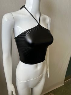 Make a bold statement with our Shakira Leather Backless Top, a perfect blend of edgy and sexy. Crafted from high-quality faux leather, this slim-fit top features a solid pattern that exudes confidence and style. The halter neckline and daring backless design create a striking silhouette, perfect for making a lasting impression. Designed for summer, this cropped halter tank keeps you cool while turning up the heat on your fashion game. Whether you're heading to a night out with friends or a speci Sleek Black Sleeveless Halter Top, Trendy Halter Top With Built-in Bra For Night Out, Black Faux Leather Top For Club, Edgy Party Tops With Built-in Bra, Edgy Tops With Built-in Bra For Night Out, Edgy Stretch Crop Top For Evening, Black Faux Leather Club Top, Trendy Fitted Faux Leather Top, Trendy Fitted Faux Leather Tops