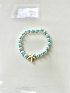 This bracelet is made out of stretchy string and clay beads. It's so adorable for the beach and summer! All orders will recieve 2 stickers and a ring for free. White Pearl Bracelet For Summer Beach, Starfish-shaped Beaded Beach Jewelry, Green Stackable Stretch Bracelet For Beach, White Beaded Pearl Bracelet For Beach, Beachy White Stretch Bracelet For Vacation, White Beachy Stretch Bracelet For Summer, White Stackable Friendship Bracelets For Summer, White Starfish Beach Jewelry, Starfish Shaped Beaded Bracelets For Beach