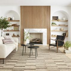 a living room filled with furniture and a fire place in front of a wall mounted fireplace