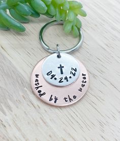 two personalized key chains with the names of different people on them and one has a cross in it