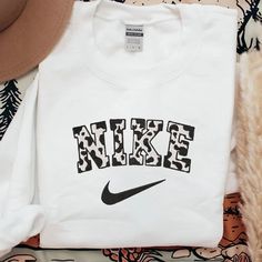 Nike Cow Embroidered Sweatshirt This All Over Nike Sweatshirt (Gildan) Is So Comfy And Cozy. True To Size Preshrunk Please Message If You Need Another Color. Cute Nike Sweaters, Last Name Sweatshirt, Cow Nike Sweatshirt, White Embroidered T-shirt For Fall, White Embroidered Logo Top For College, White Letter Embroidery T-shirt For Streetwear, White Long Sleeve T-shirt With Embroidered Logo, Sporty White T-shirt With Embroidered Text, White Cotton Sweatshirt With Letter Print