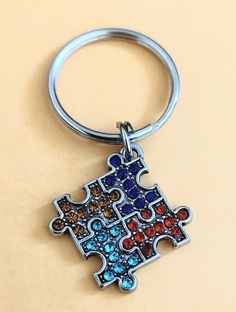 a metal keychain with a puzzle piece design on it's front and back sides