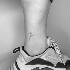 a woman's foot with a small tattoo on the side of her leg,