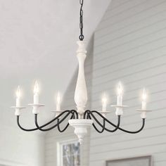 a white chandelier with six lights hanging from it's centerpiece in a living room