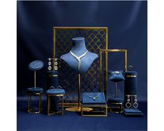 a blue display case with jewelry on it and other items in front of the mannequin