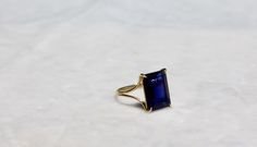 "A very high quality VVS1 dark blue iolite rectangle, emerald cut gem takes centerstage with this beautiful simple design. It's a modern/classic look that is very easy to wear and is sure to become one of your everyday ring. The shank is a split design, semi-rounded and 1mm thick. The size is 7. I ONLY MADE ONE BECAUSE THERE IS ONLY ONE OF THIS GEM IN THAT PARTICULAR COLOR AND SHAPE, BUT THIS RING CAN BE ADJUSTED TO ANY SIZE. PLEASE ALLOW A MINIMUM OF 3 WEEKS FOR ME TO RESIZE THE RING. IOLITE is Formal Square Cut Sapphire Ring, Emerald Cut Tanzanite Sapphire Ring, Formal Sapphire Ring With Radiant Cut, Formal Radiant Cut Sapphire Ring, Radiant Cut Tanzanite Jewelry With Prong Setting, Elegant Sapphire Ring With Emerald Cut, Modern Radiant Cut Sapphire Ring For Formal Occasions, Rectangular Sapphire Anniversary Ring, Elegant Radiant Cut Sapphire Ring