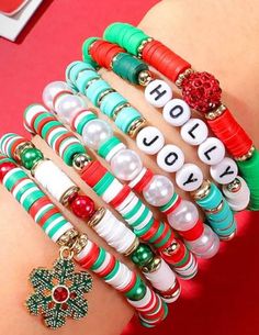 the bracelets are all different colors and designs on each arm, with words that spell out holiday