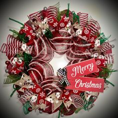 a red and white christmas wreath with merry lettering on it's front door hanger