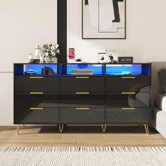 a black and gold dresser in a white room with a blue light on the top