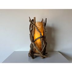 a lamp made out of driftwood with a light bulb on it's side