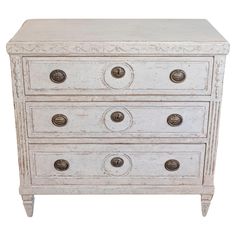 an old white dresser with four drawers