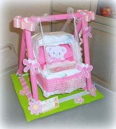 a pink and white baby's crib cake on top of a green mat