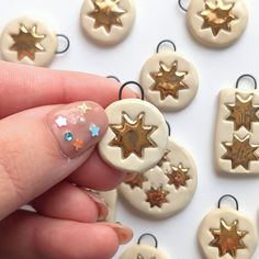 a hand with some gold and white stars on it's thumb next to small buttons