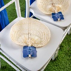 two white chairs with blue tags on them and one chair is made out of wicker