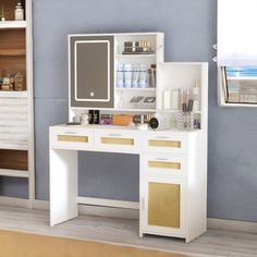 a white vanity with gold accents in a blue room next to a mirror and shelves