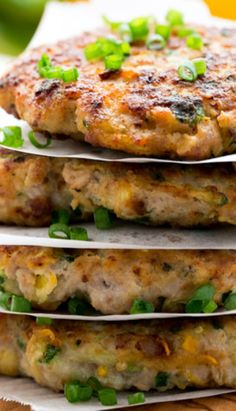 three crab cakes stacked on top of each other with green onions and scallions