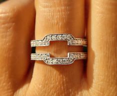 a woman's hand with two wedding bands on her ring, and the band is made out of white diamonds