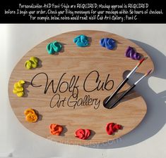 a wooden sign that says wolf cub art gallery on it with paint and crayons