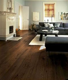 a living room filled with furniture and a fire place next to a fireplace on top of a hard wood floor