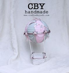 a pink and blue hot air balloon with the words cby handmade above it