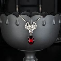 "Add some Gothic glamour to your wardrobe with this blood red jeweled necklace!! It would make a great collection to any bat lover's accessory collection! 💀 DESCRIPTION: This pendant necklace features a fabulously detailed face of a screaming bat. A faceted oval rhinestone from Swarovski®, in Siam, dangles from the bottom. The twisted bar chain was finished with a lobster clasp and an extender. 💀 SIZE & MATERIALS: The vintage rhinestone measures 3/4\" by 1/2\" (18x13mm) The stamping was made f Gothic Glamour, Jeweled Necklace, Bat Pendant, Bat Jewelry, Gem Pendant, Vampire Bat, July Birthday, Blood Red, Birthday Gift For Her