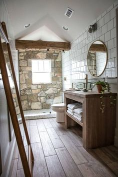 a bathroom with stone walls and wooden floors