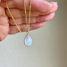 Rainbow Moonstone Necklace, June Birthstone, White Teardrop Pendant on Satellite Ball Layering Chain in Gold or Silver, Dainty Gift for her This simple stunning gemstone necklace features a gorgeous blue flash faceted teardrop bezeled stone in 14k Gold Filled or Sterling Silver. The white moonstone pendant is suspended from a minimalist satellite ball chain in the finish of your choice. This necklace is simple, elegant and just perfect for layering or to wear on its own. It make a great bridesmaid necklace. This Boho Necklace will turn heads at any of your social events. Please note that the blue flashes in the stones may vary from pendant to pendant, but they are all very similar to one another.  About this Necklace: - Gemstone: Blue flash Rainbow Moonstone - Birthstone: June - Moonstone Moonstone Birthstone, Moonstone Properties, Rainbow Moonstone Necklace, White Moonstone, June Birthstone, Teardrop Pendant, Moonstone Necklace, Necklace Gemstone, Bridesmaid Necklace